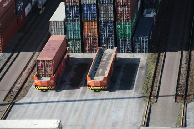 Two container carriers, one loaded and one empty, at a terminal