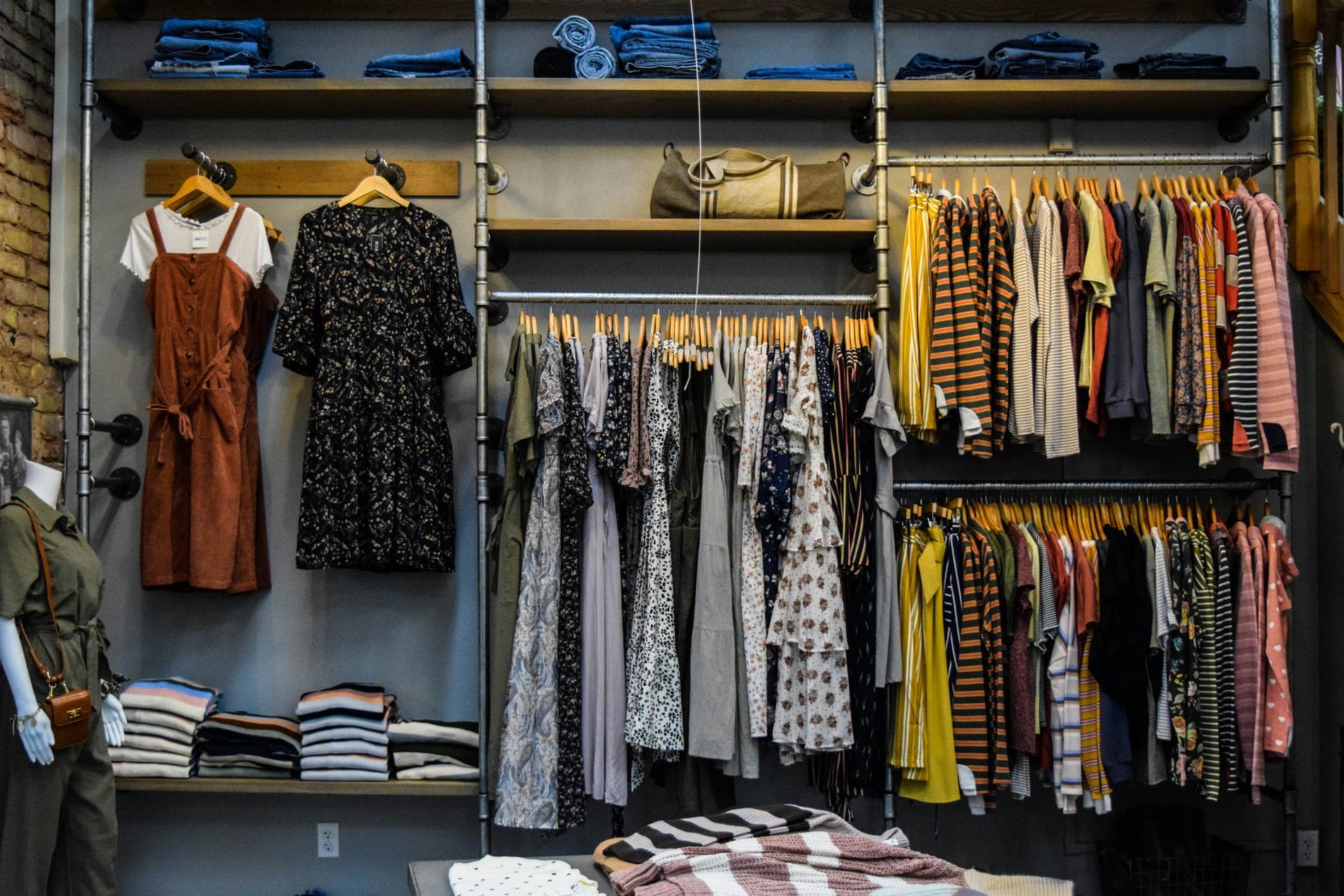 A wall of dresses, shirts and folded sweaters on open shelves