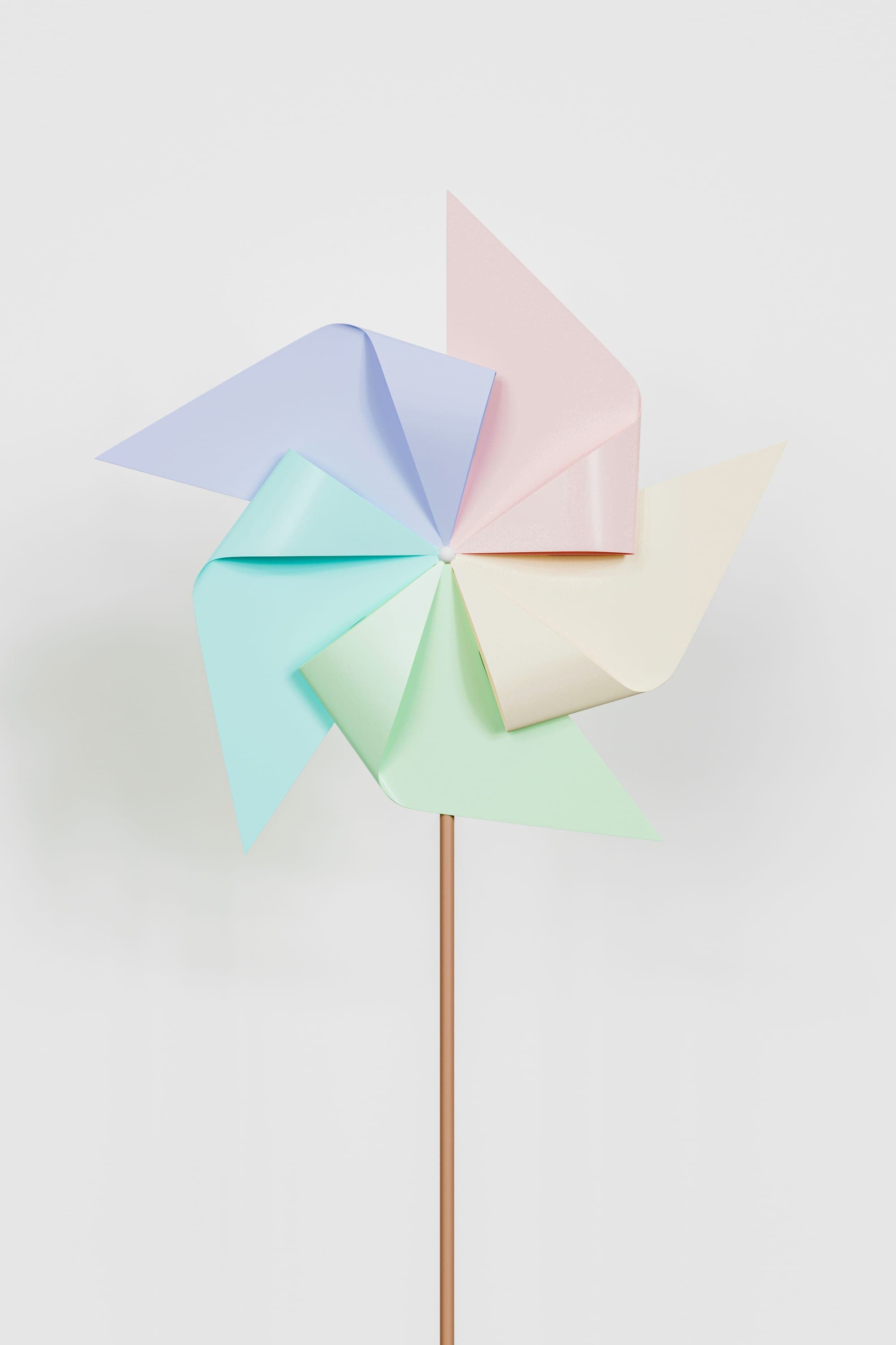 A pastel paper pinwheel on a white background